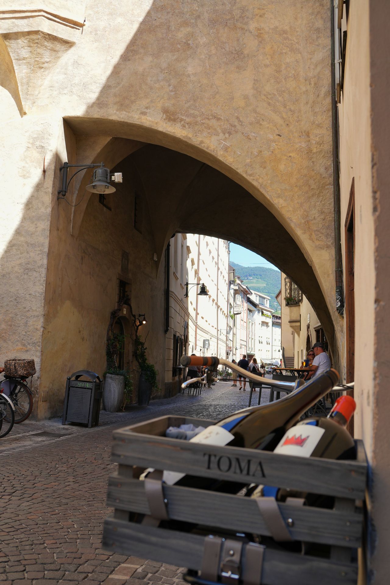 Wine bottles displayed outside a traditional wine bar in a Bolzano old town alleyway, South Tyrol, Italy