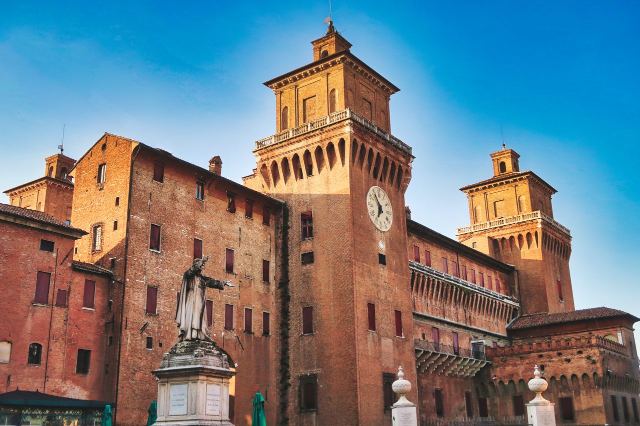 Castello Estense medieval moated castle rising above Ferrara, Emilia-Romagna, Italy under blue skies