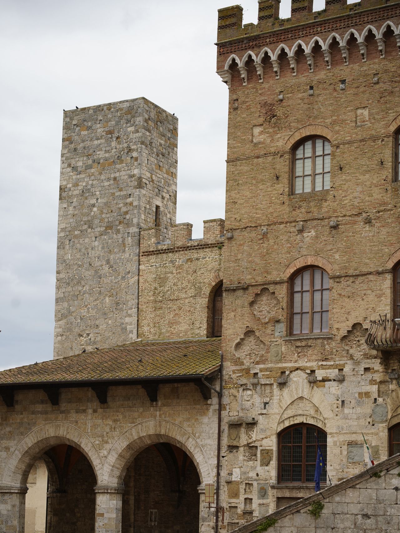 Medieval stone towers rising above the rooftops of San Gimignano under a blue sky, Tuscany, Italy