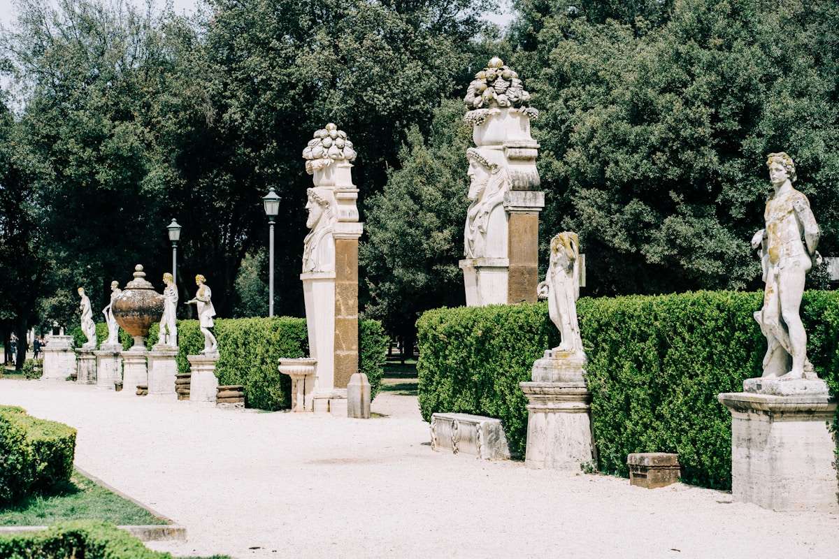 Classical statues lining a garden path at Villa Borghese, Rome, Italy