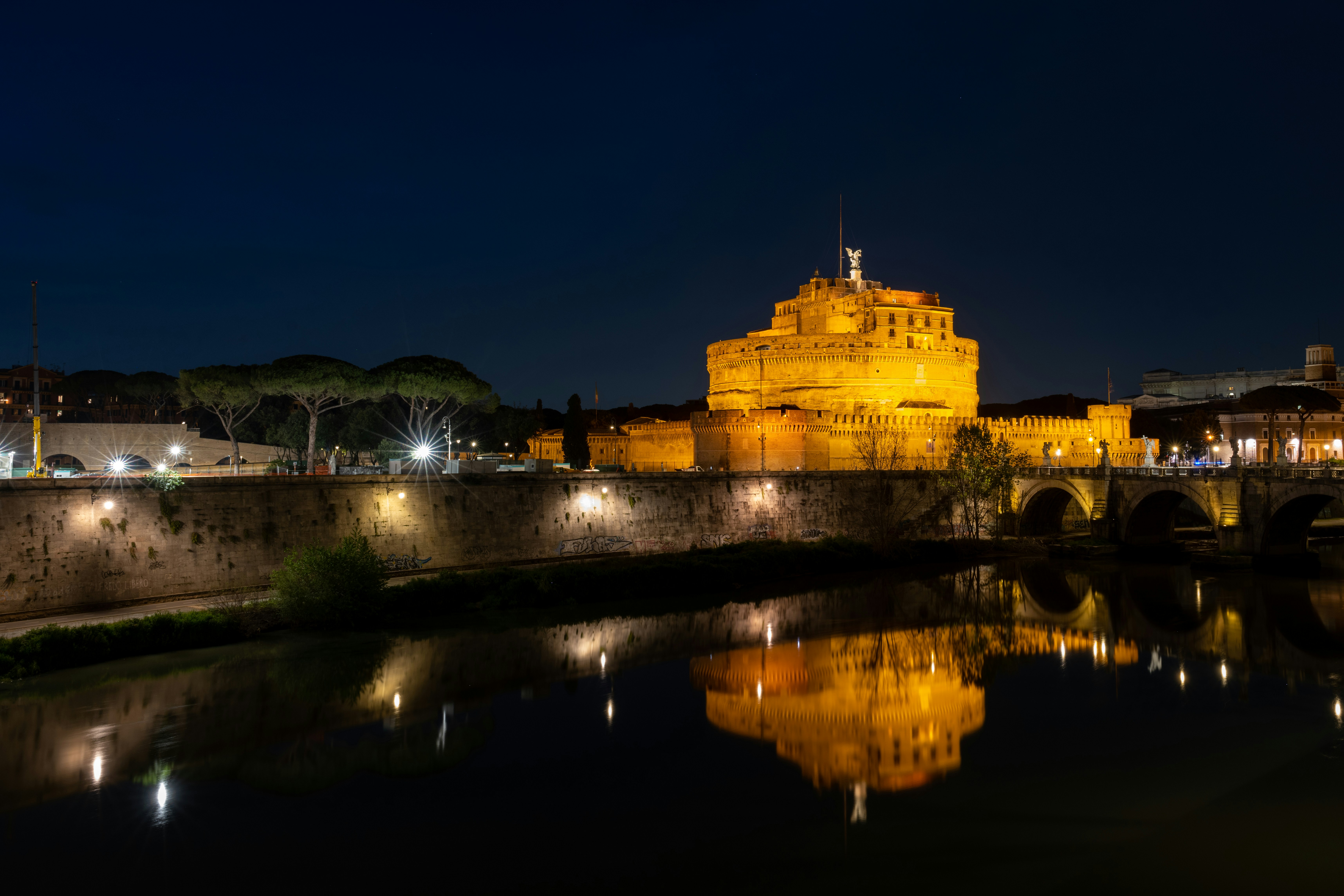 Castel Sant'Angelo illuminated at night reflected in the Tiber river, Rome, Italy