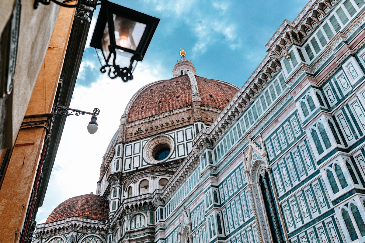 Brunelleschi's dome and marble facade of Florence Cathedral seen from a narrow street