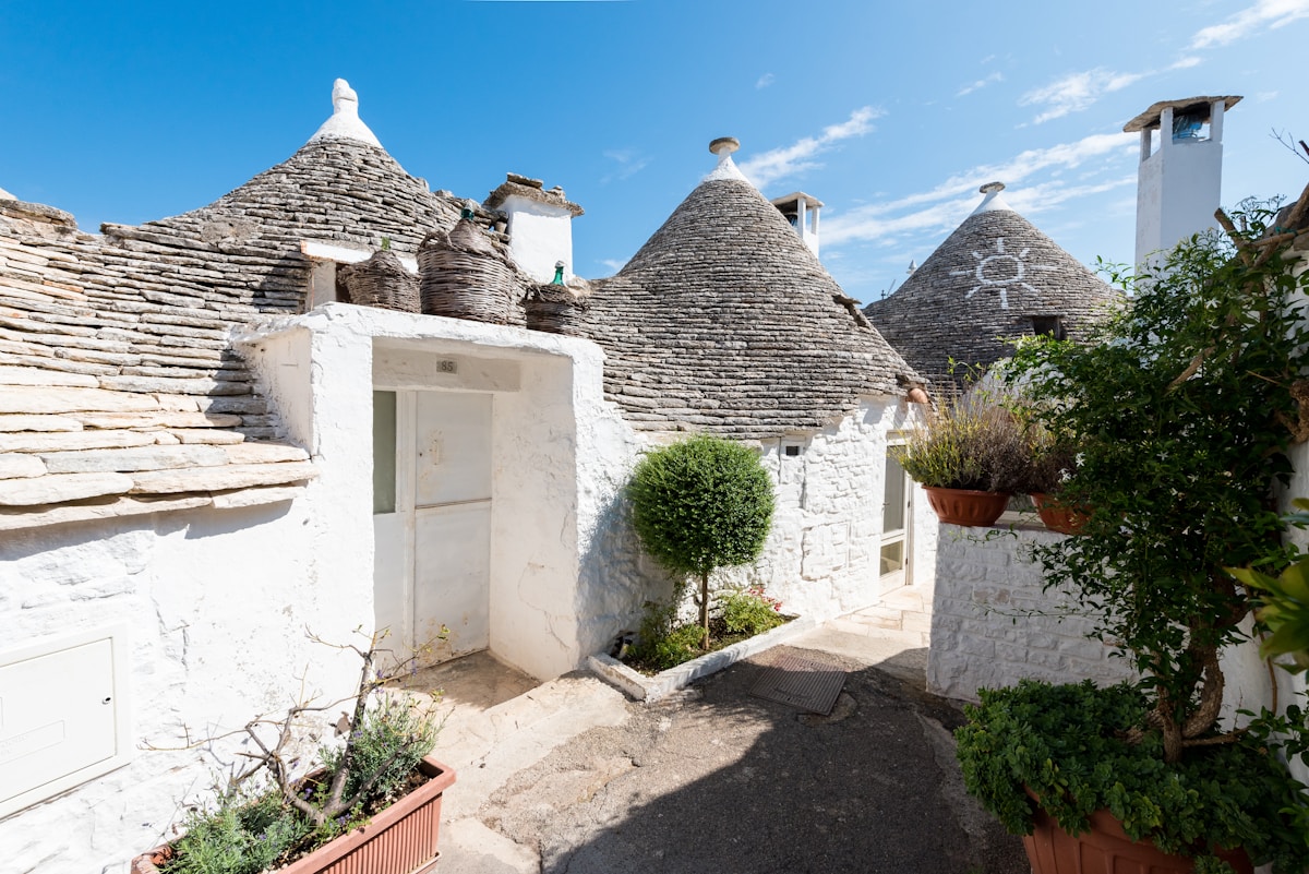 Interior of a converted trullo hotel room with conical ceiling and stone walls in Alberobello, Puglia