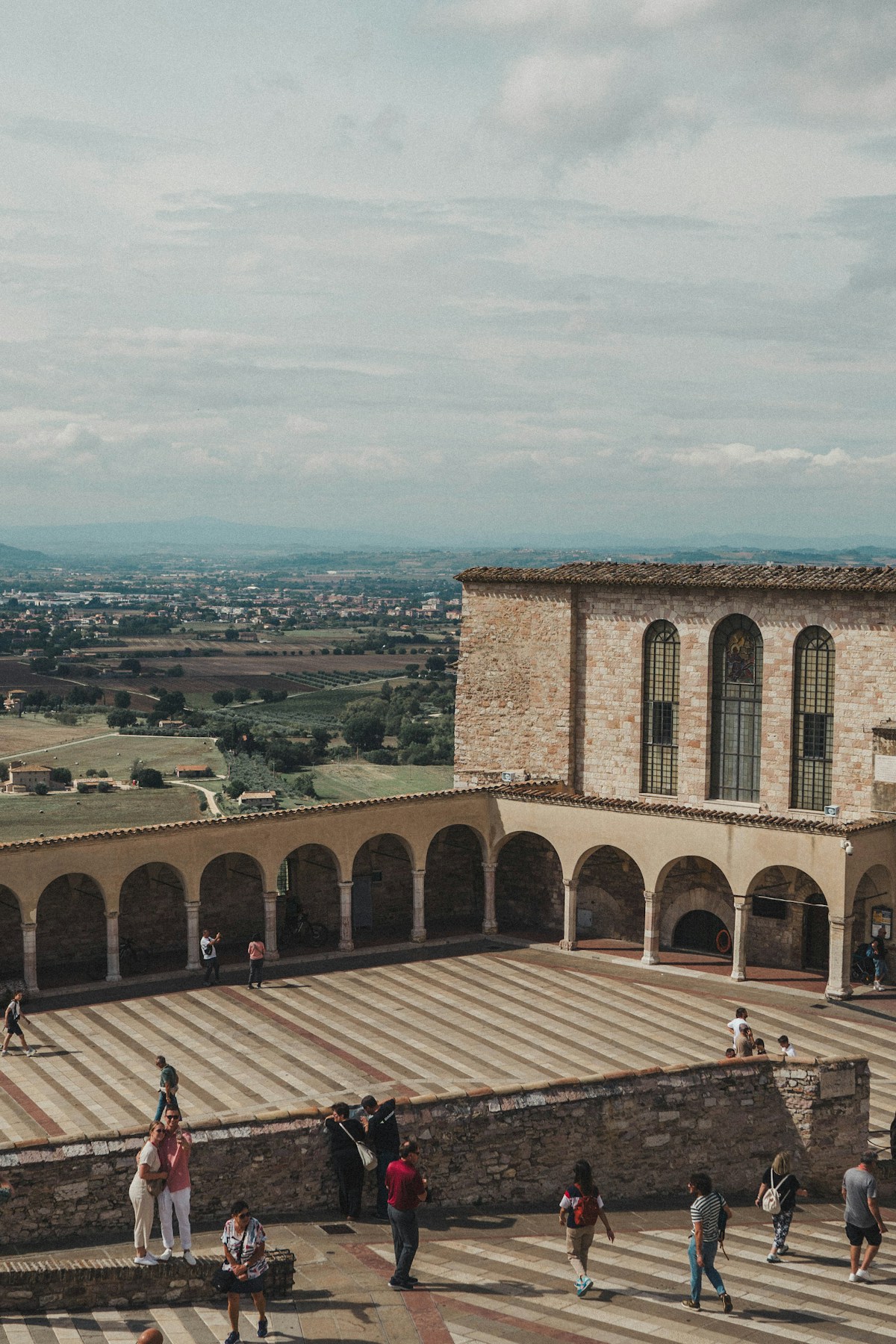Group of people standing on top of a stone building, Assisi, Umbria, Italy