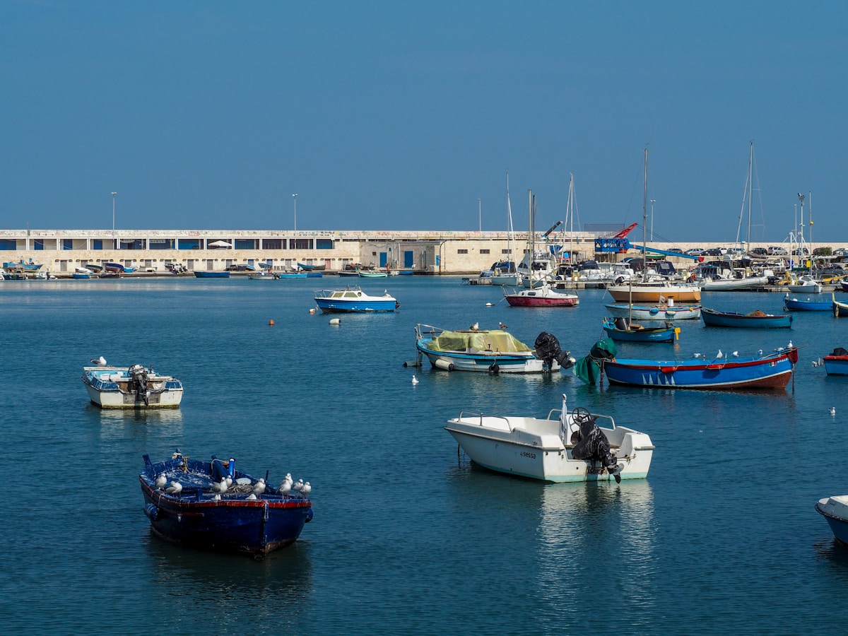 Fishing boats in Bari harbour on a calm clear day, Puglia, Italy