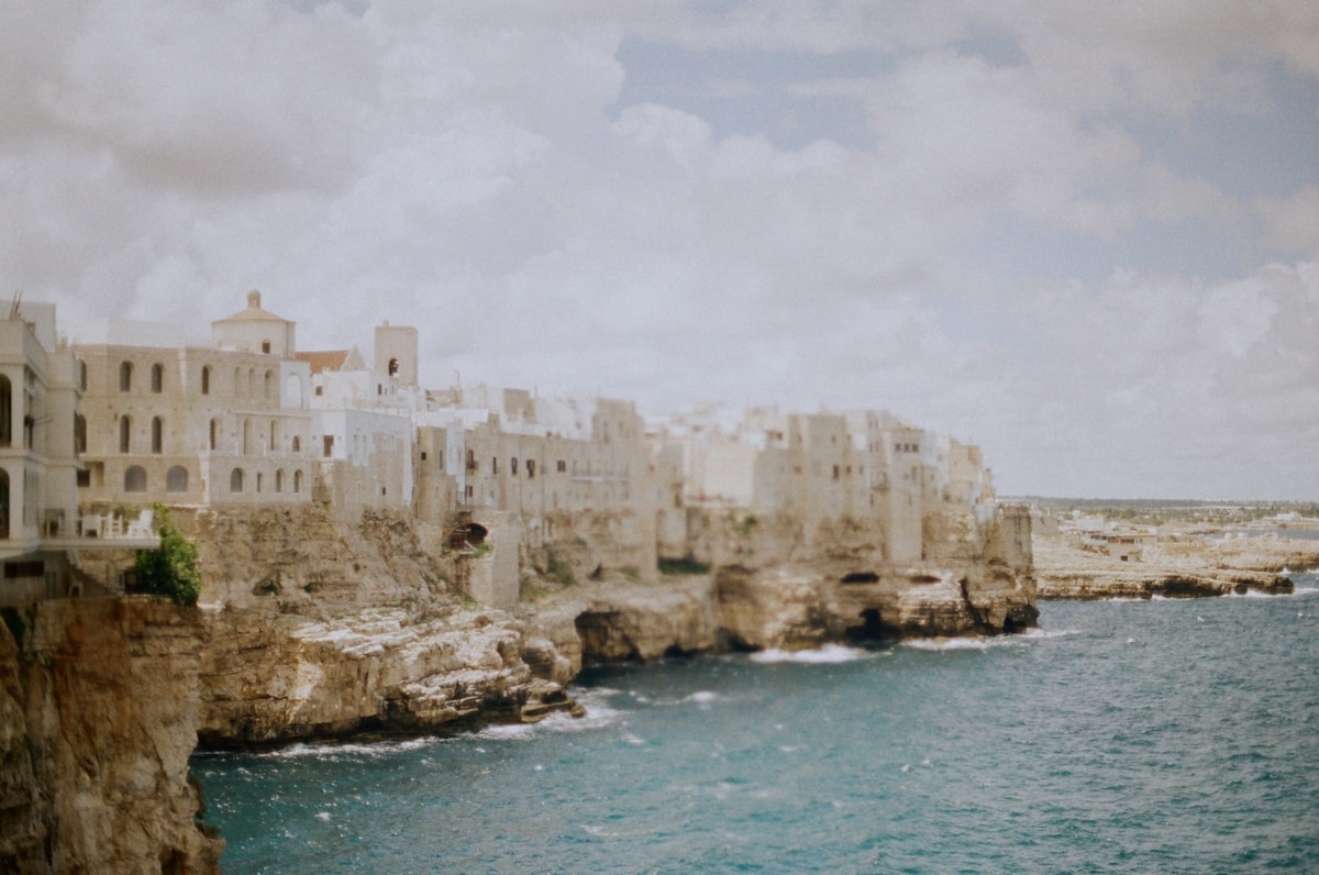 Cliffside buildings overlooking bright blue ocean, Polignano a Mare, Puglia, Italy