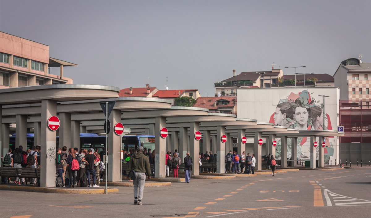 Bus station with people waiting under concrete canopy, Bergamo, Lombardy, Italy