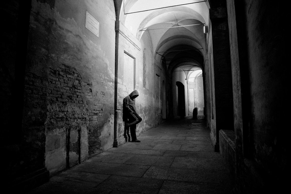 Man in portico arcade alleyway, Bologna, Emilia-Romagna, Italy