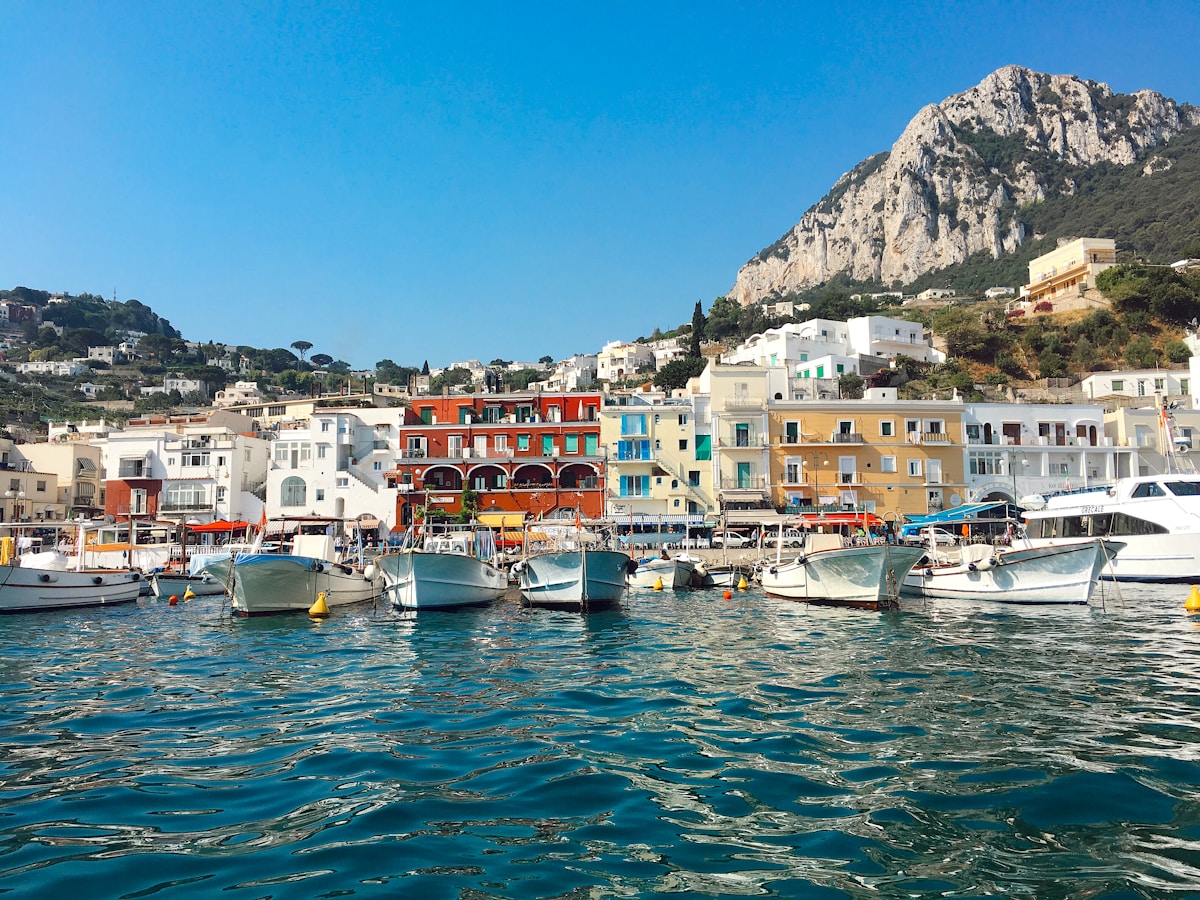 Boats moored at Marina Grande below the colourful harbour buildings, Capri, Bay of Naples, Italy