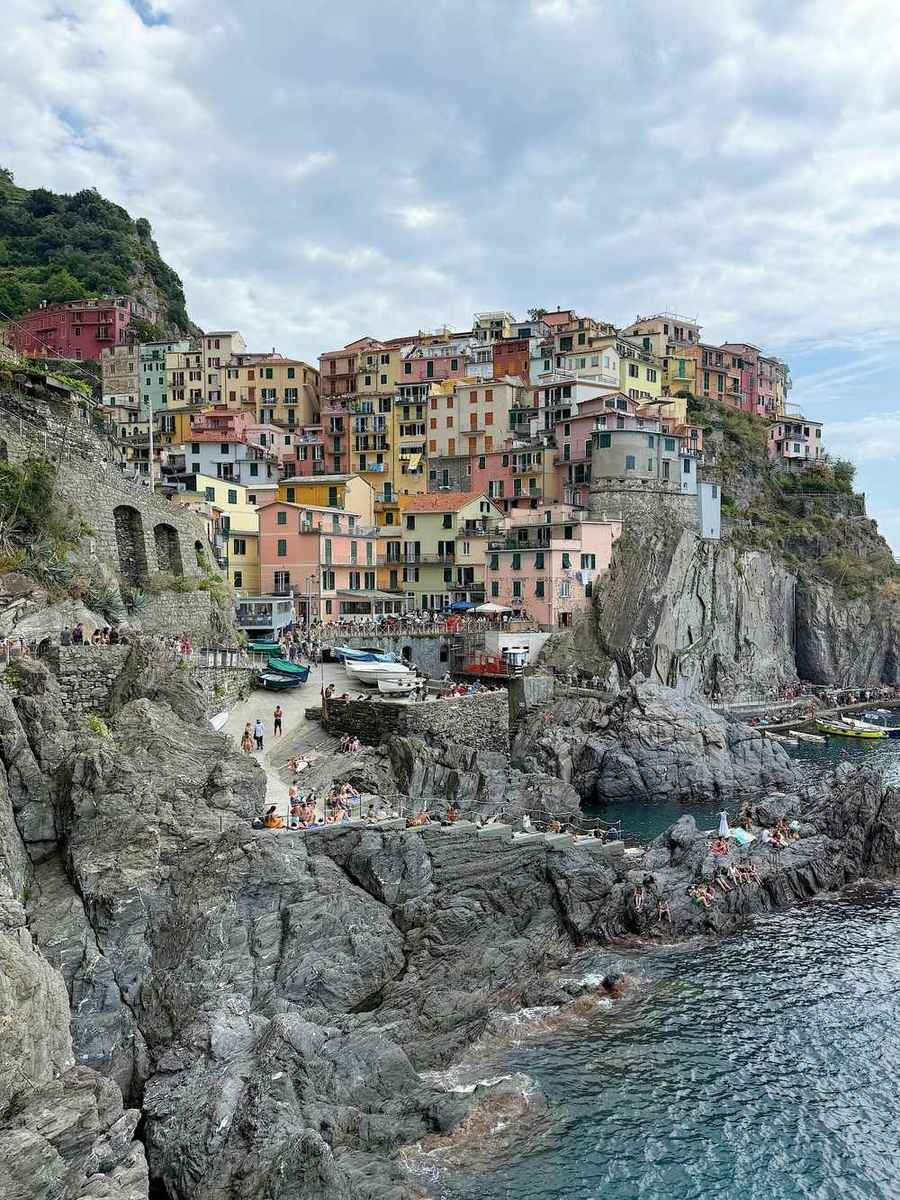 Colourful buildings cling to a rocky cliff overlooking the sea, Cinque Terre, Liguria, Italy