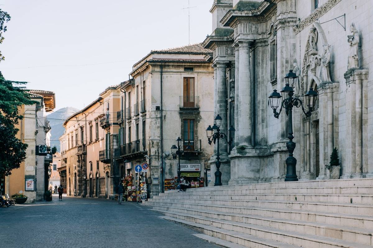 Cobblestone main street in Sulmona with Baroque church facade, Abruzzo, Italy