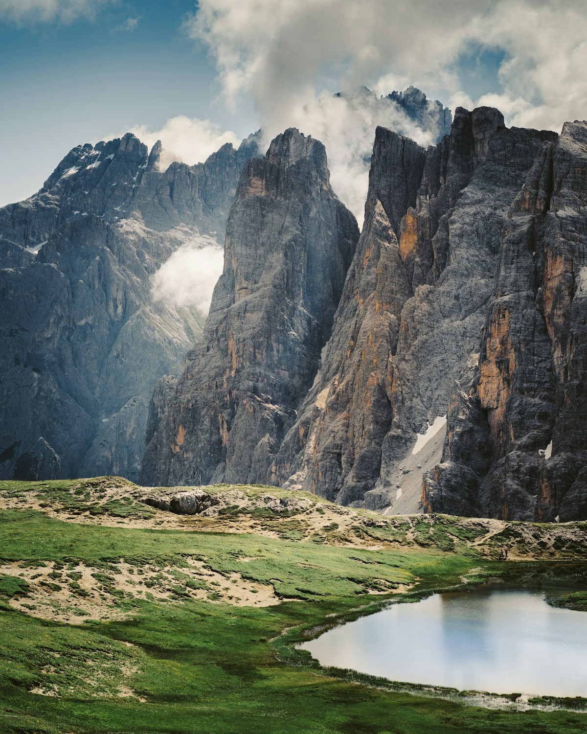 Green grass field near rocky mountain, Val Fiscalina, Dolomites, Italy