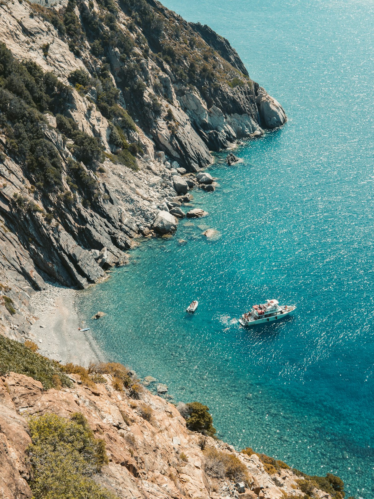 Boat anchored in a clear mountain cove, Caletta Paradiso, Marciana, Elba island, Italy