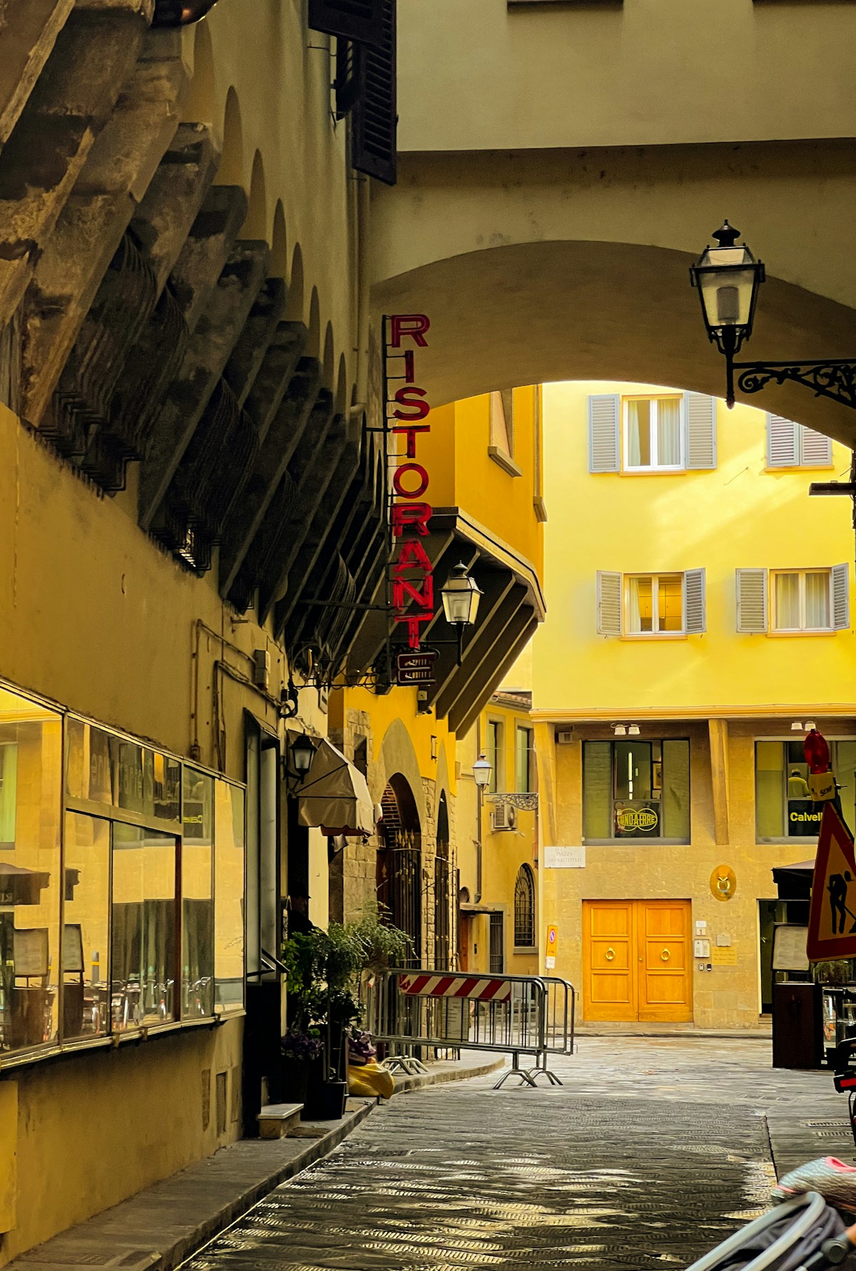 Narrow city street with a yellow building, Florence, Italy