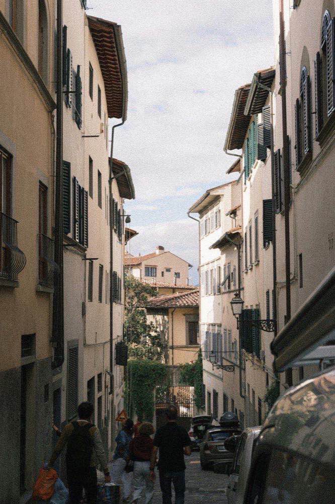 Narrow residential street with Florentine buildings and green shuttered windows in a Florence neighbourhood