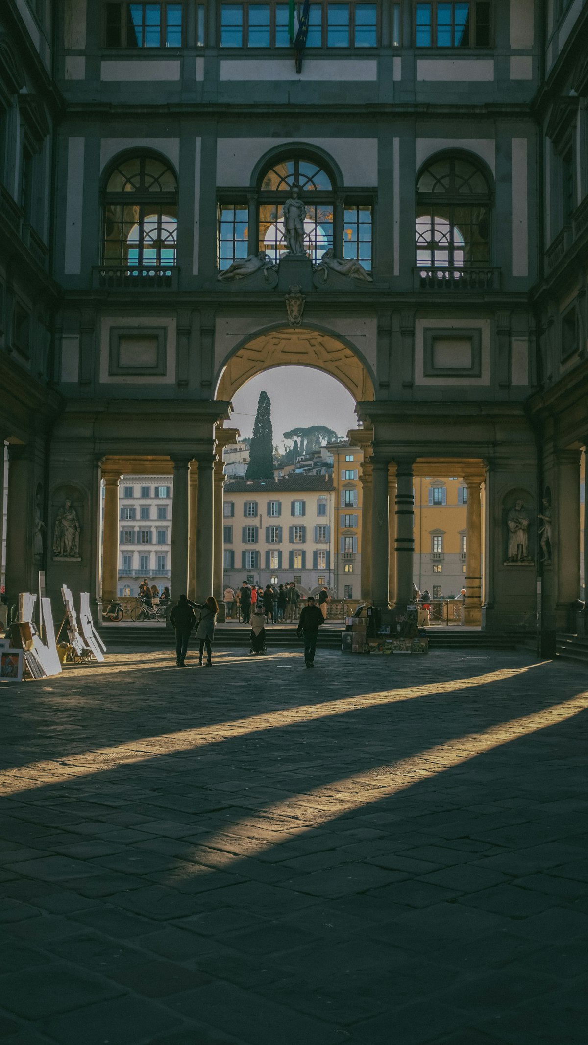 The courtyard of the Uffizi Gallery in Florence, Italy, with people walking through
