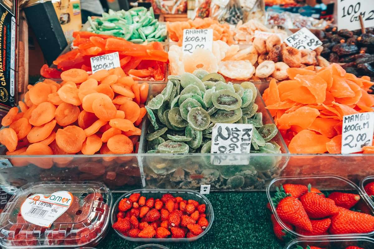 Colourful dried fruits and produce displayed at an Italian food market stall with price tags in euros