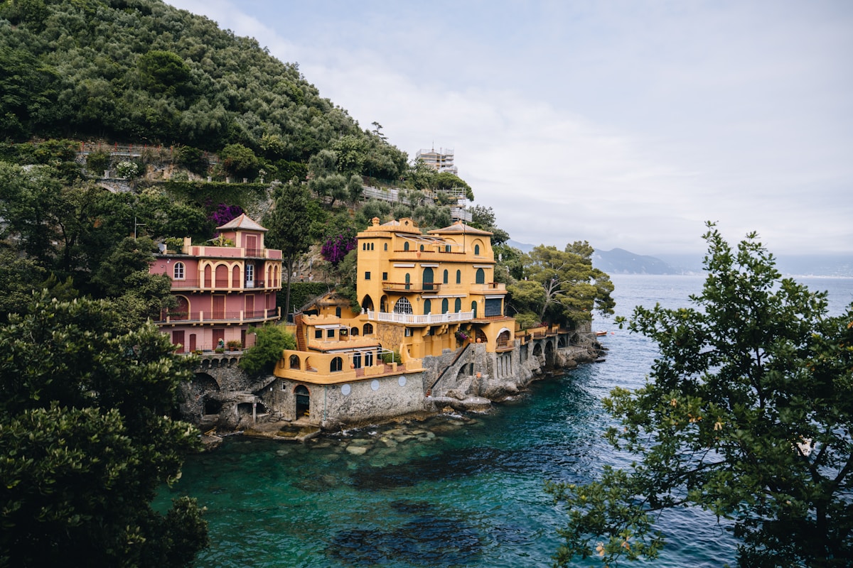 Colourful Italian villas perched on a cliff above turquoise water, Portofino, Liguria, Italy