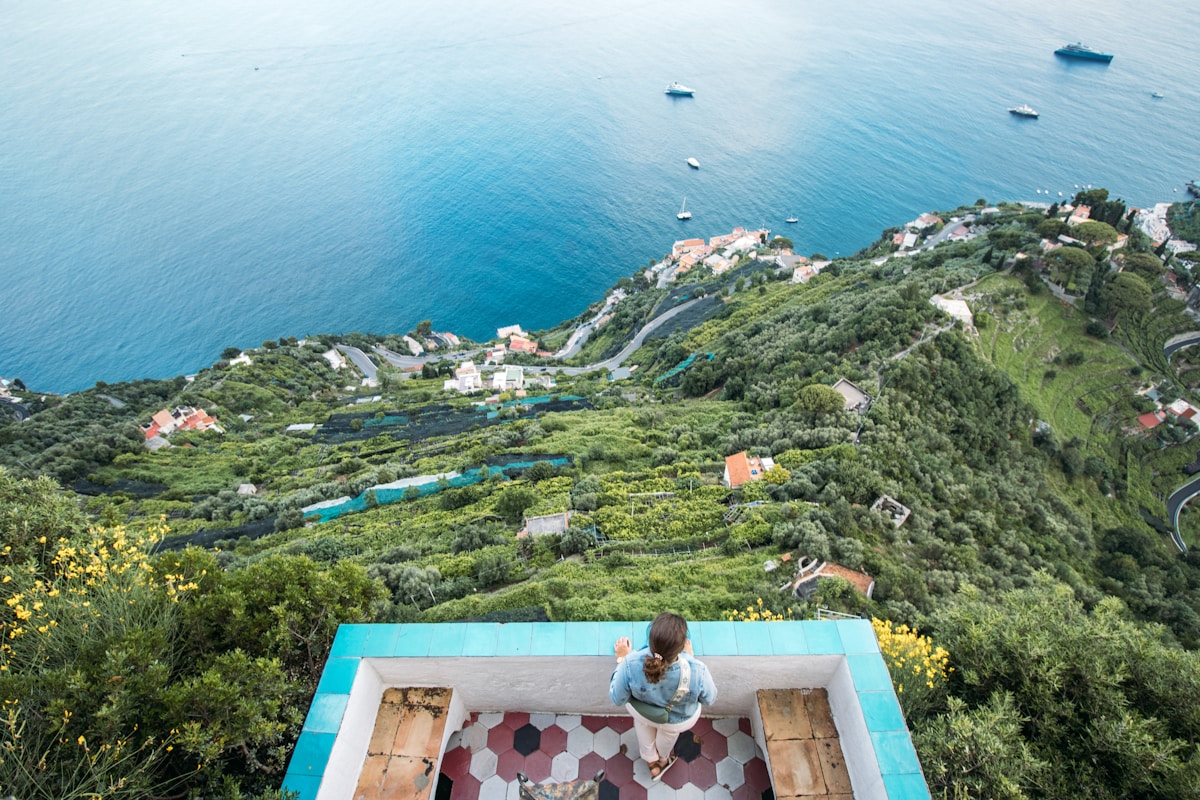 Person on a scenic Ravello viewpoint overlooking coastal terraces and the blue Tyrrhenian Sea, Amalfi Coast, Italy