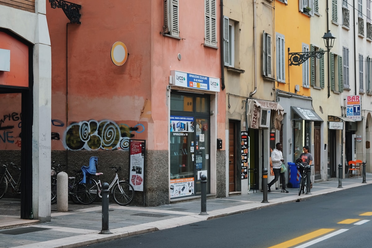 Colourful street scene with bicycles and shuttered buildings in central Parma, Emilia-Romagna, Italy
