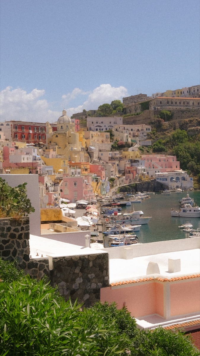Colourful pastel buildings and fishing boats in the Marina Corricella harbour, Procida island, Italy