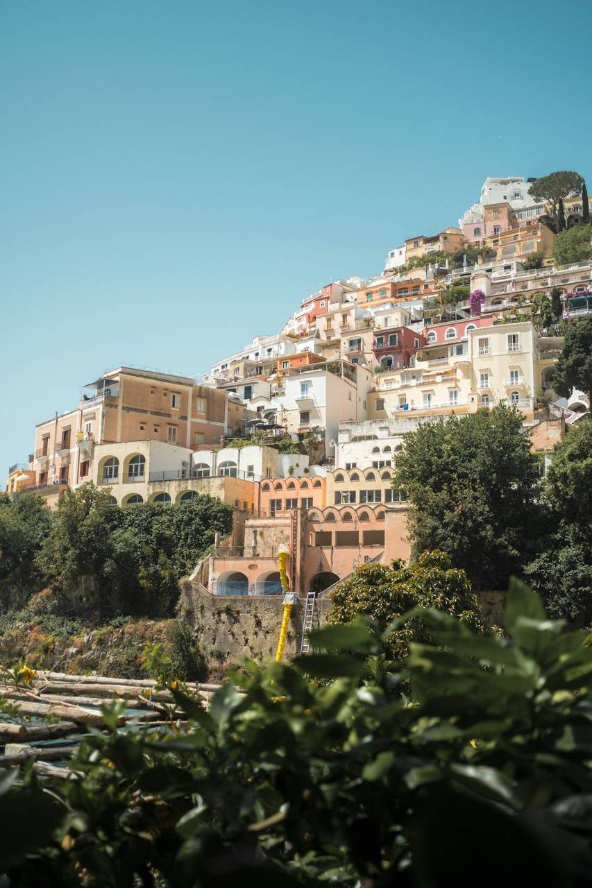La cascade colorée des bâtiments de Positano accrochés aux falaises au-dessus de la mer Tyrrhénienne, avec des bateaux dans la baie