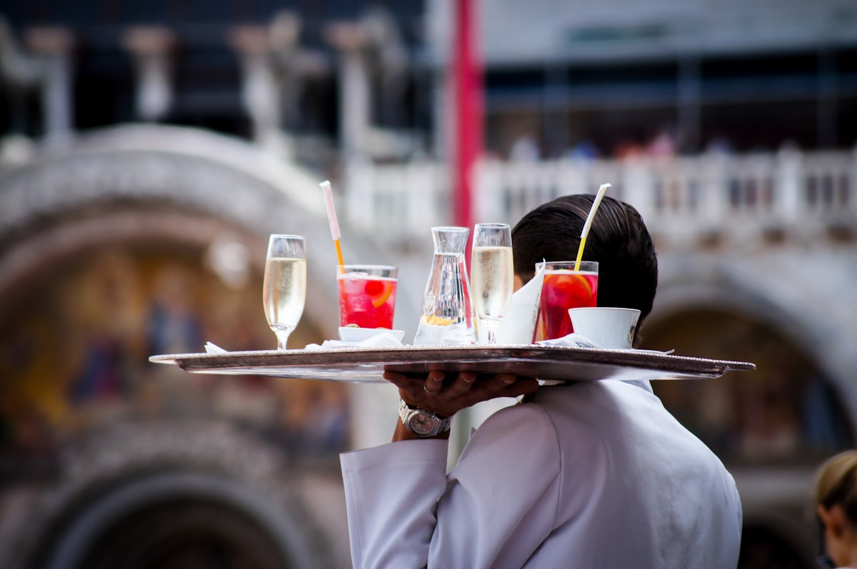Waiter serving beverages at Italian cafe, Venice, Italy