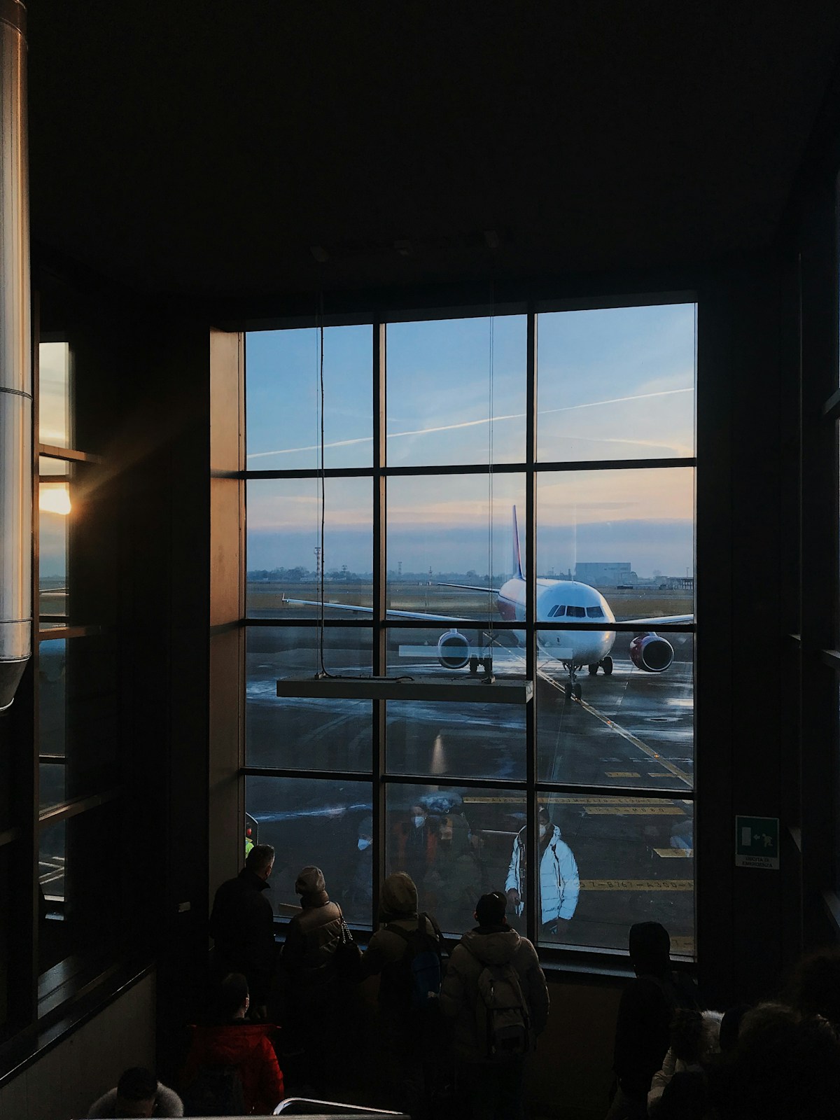 People looking out a window at an airplane, Italy travel preparation