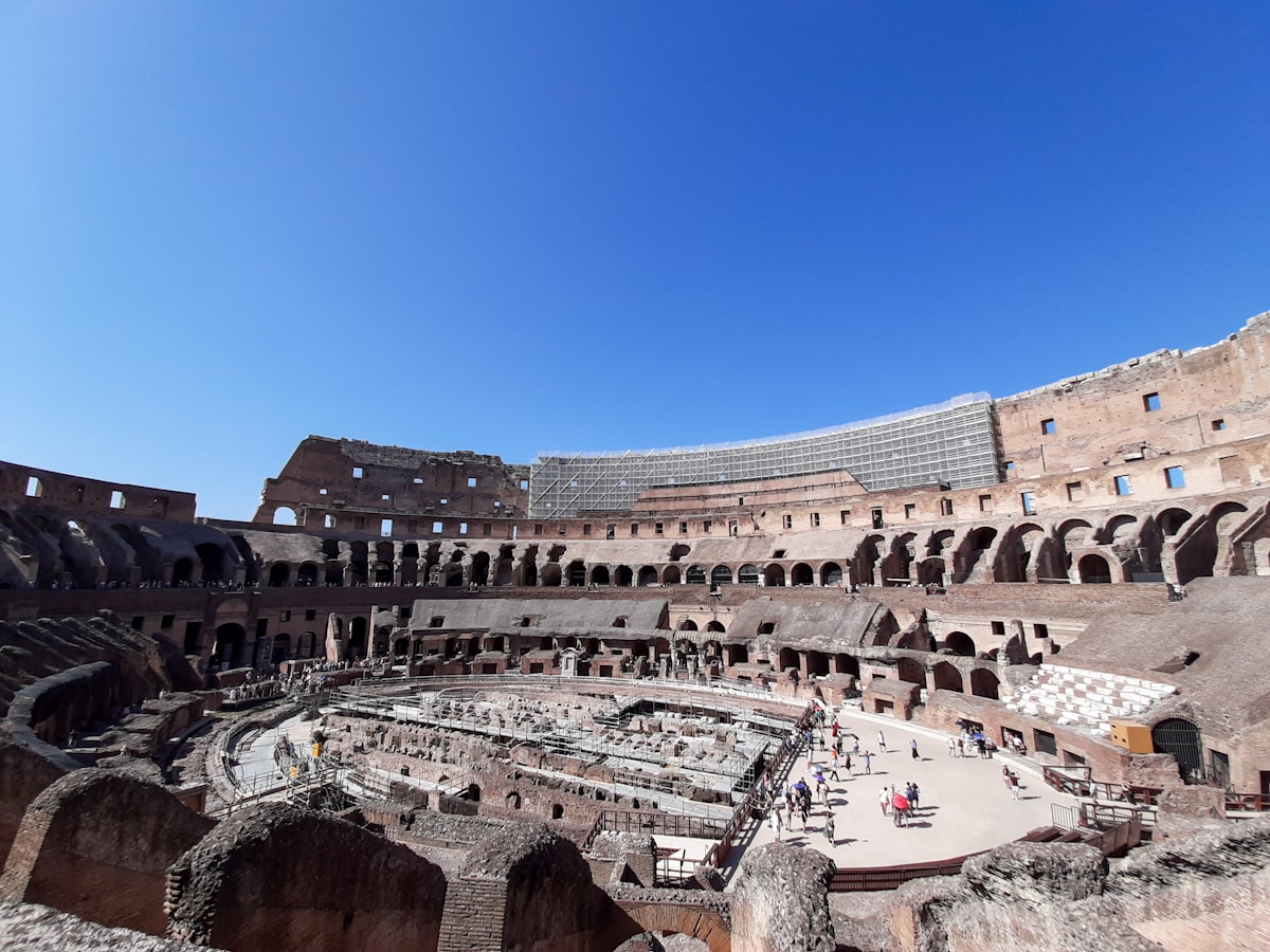 The Colosseum in Rome at golden hour against a blue sky