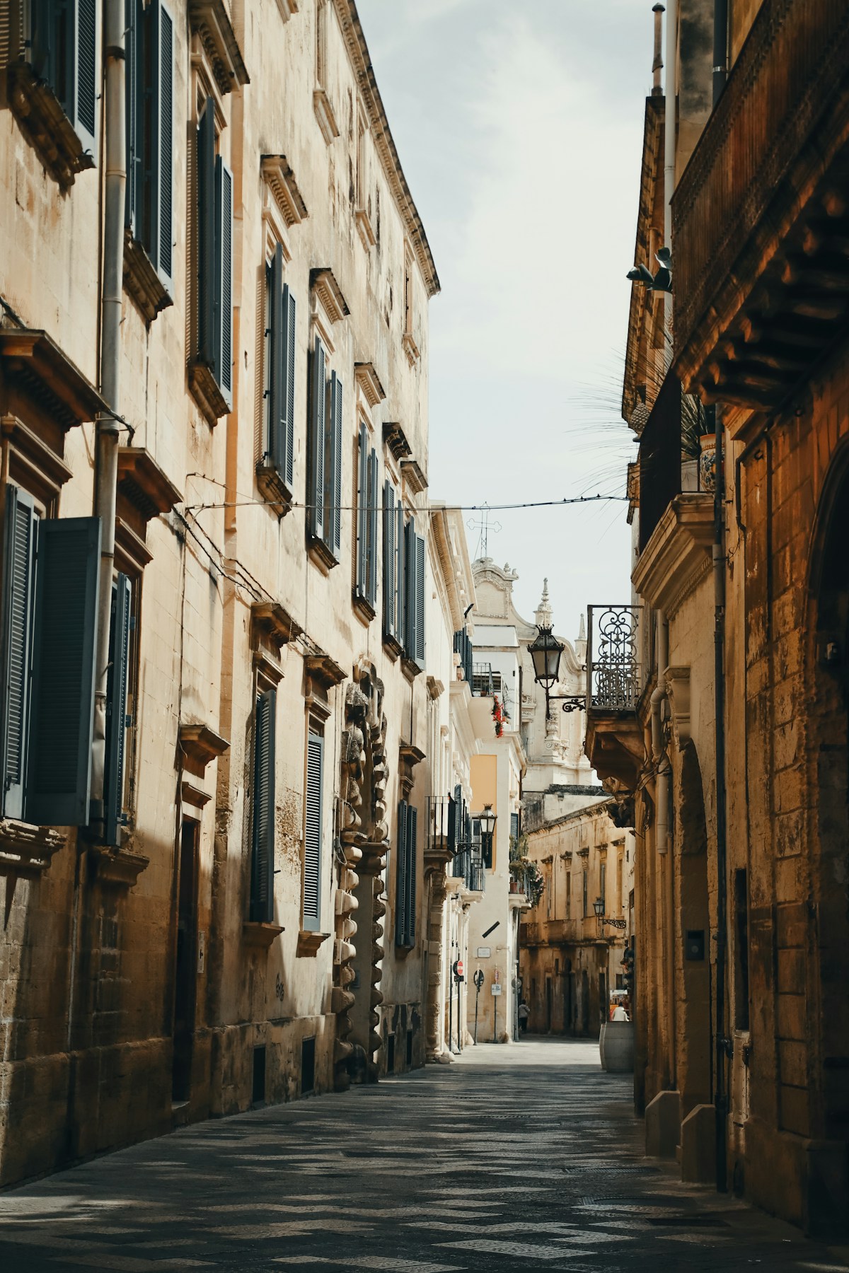 Narrow street lined with stone baroque buildings, Lecce, Puglia, Italy