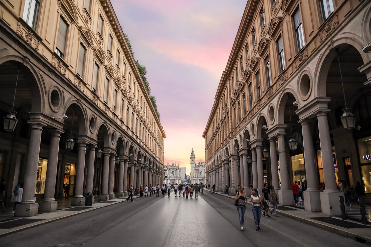 People walking on street between buildings in Turin, Italy