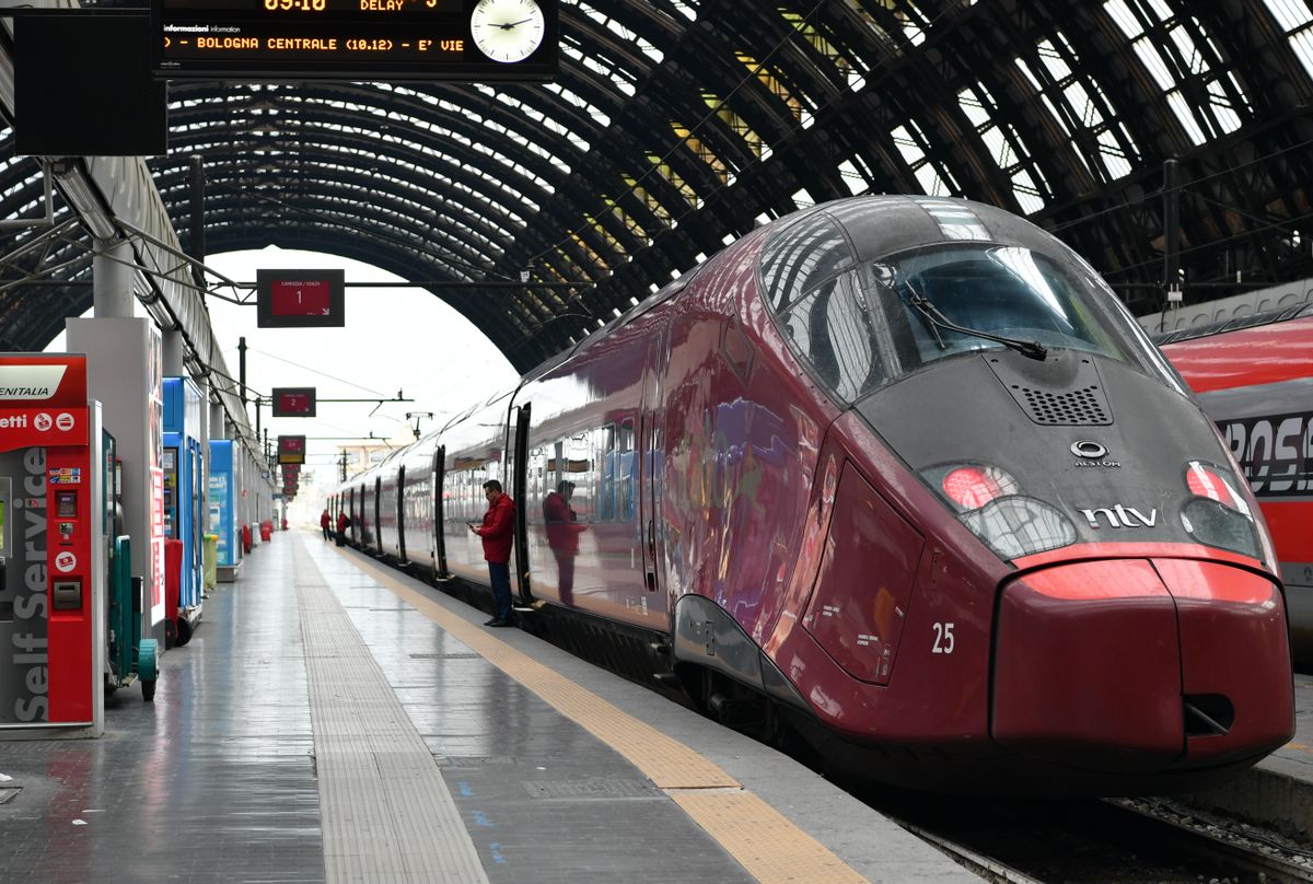 Italo high-speed train at Milano Centrale station with departure board showing Bologna, Italy