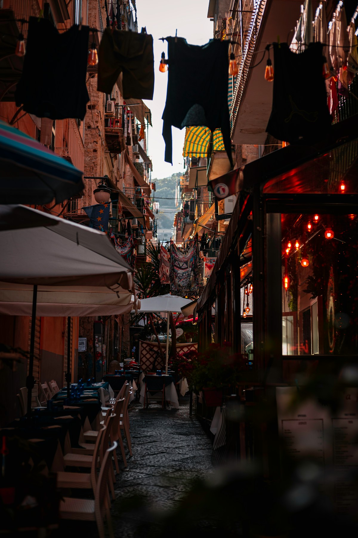 Narrow street with tables and umbrellas, Quartieri Spagnoli, Naples, Italy