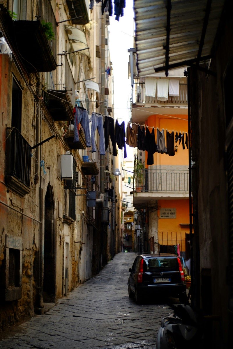 Narrow Neapolitan alleyway with laundry hanging between old residential buildings in Naples