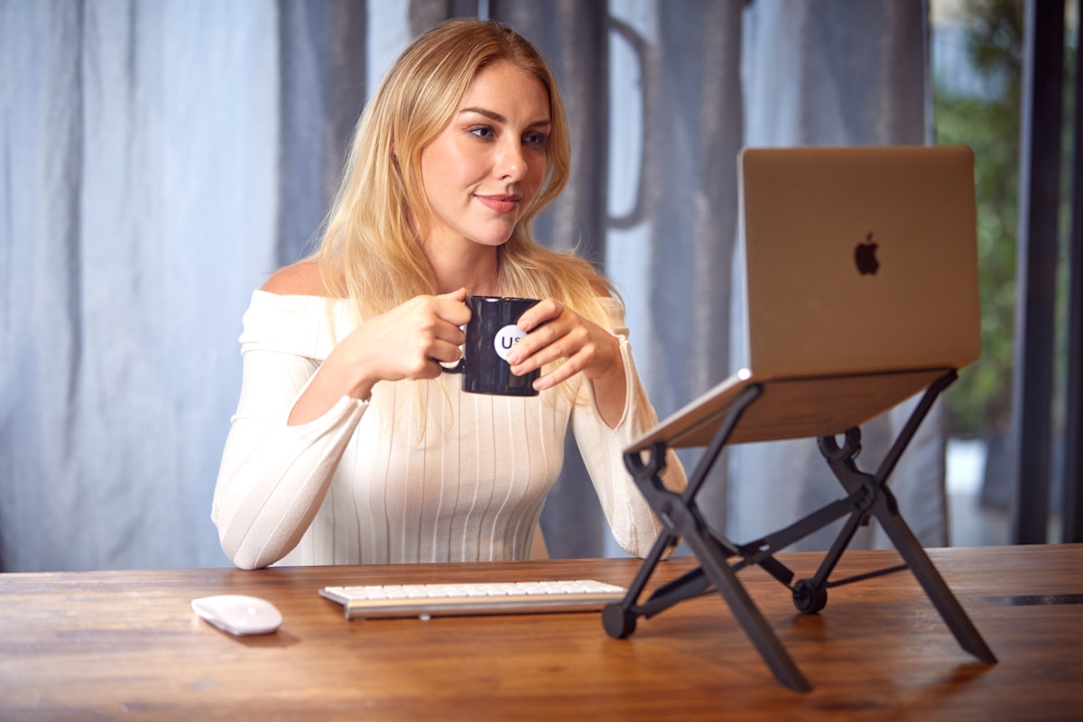 Woman with laptop and coffee at cafe table, remote working in Italy