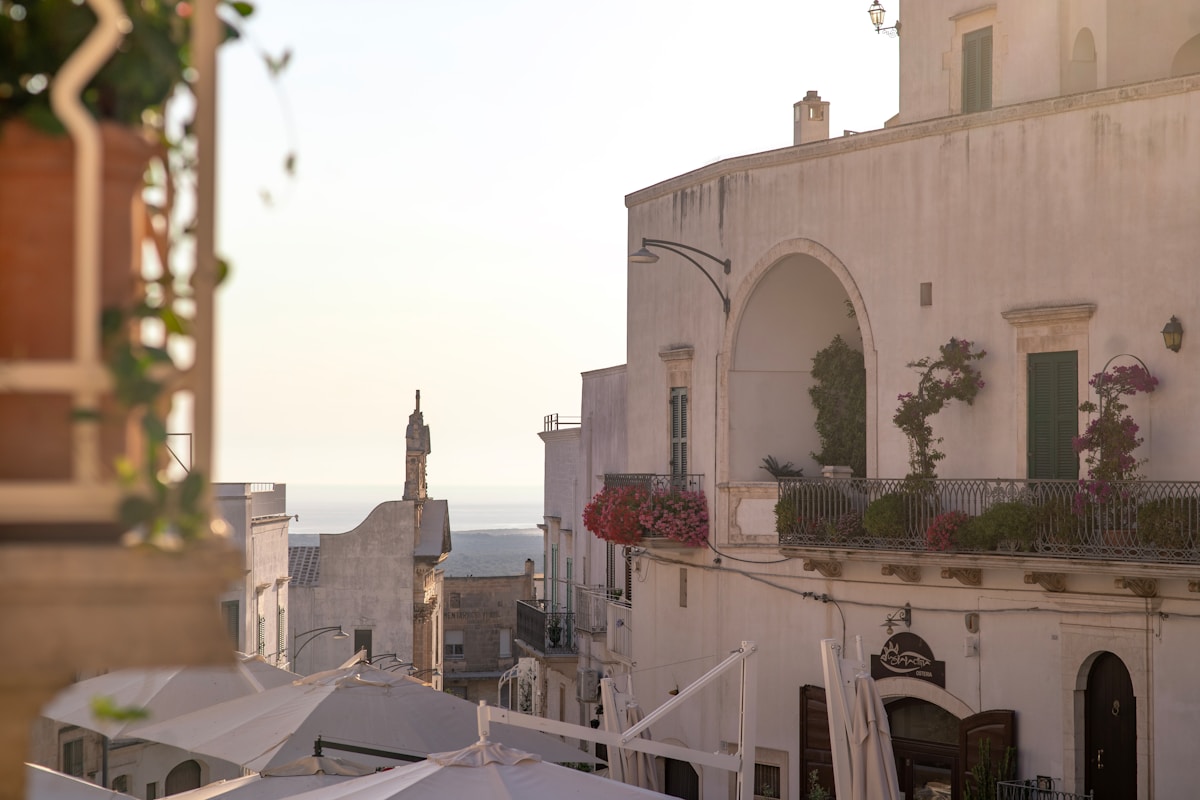 Whitewashed masseria hotel courtyard with olive trees and a pool near Ostuni, Puglia