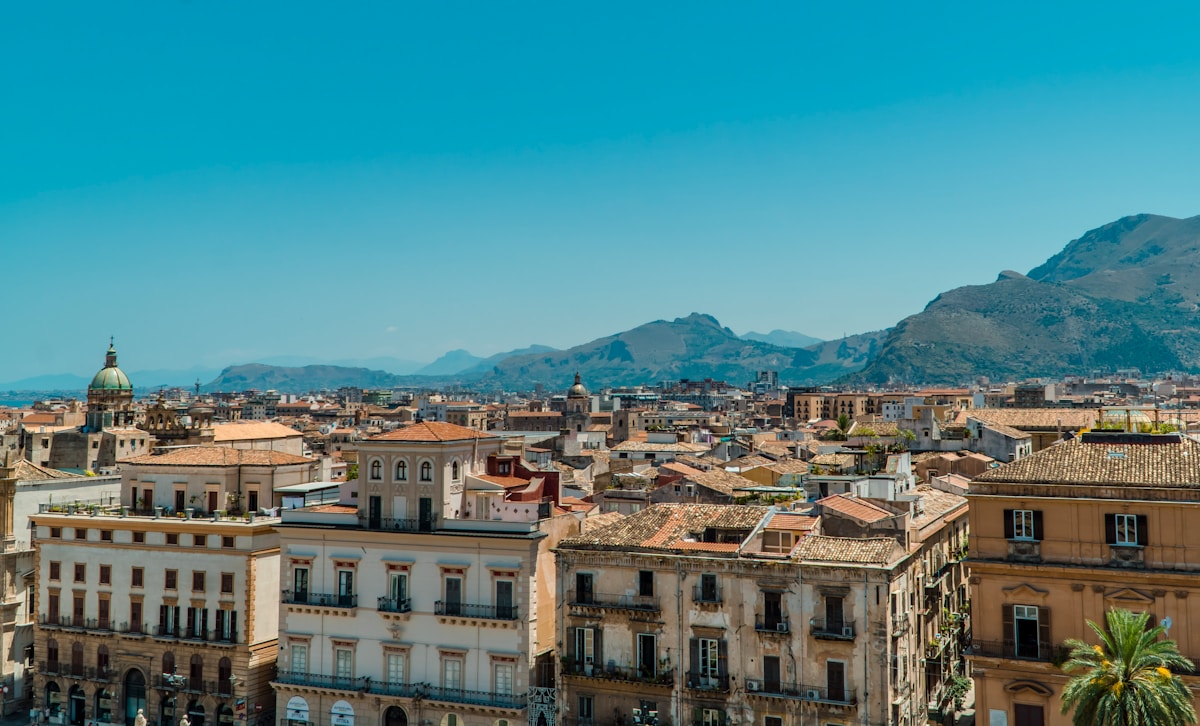Panoramic view of Palermo rooftops with church domes and mountains behind, Sicily, Italy