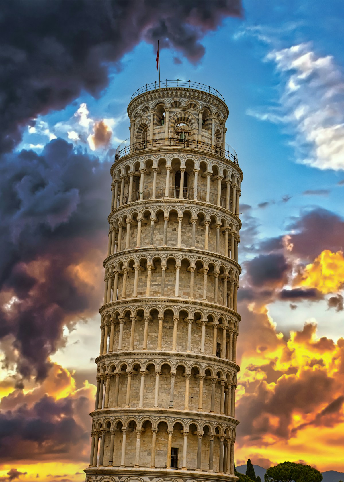 Leaning Tower of Pisa against a dramatic sunset sky, Tuscany, Italy