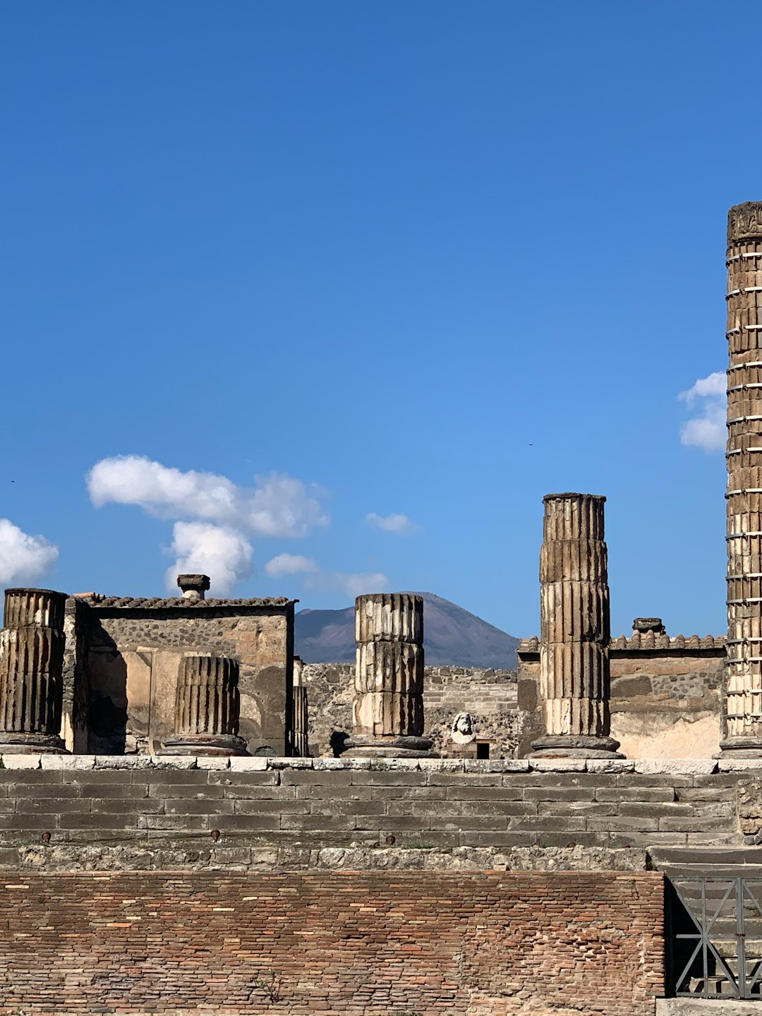 Ancient columns of Pompeii's Forum with Mount Vesuvius visible in the background