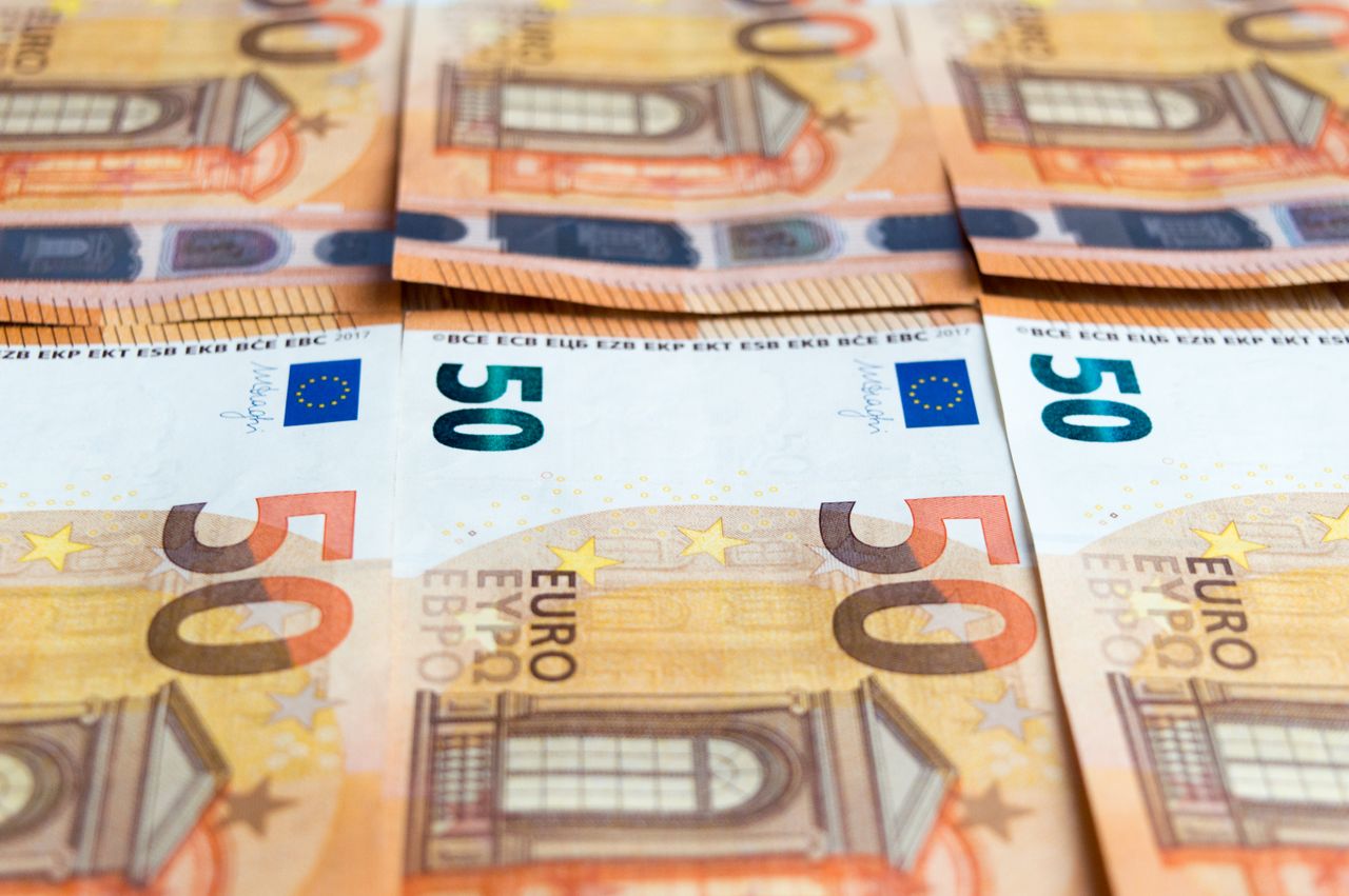 Euro banknotes and coins spread on a surface, Italy currency guide