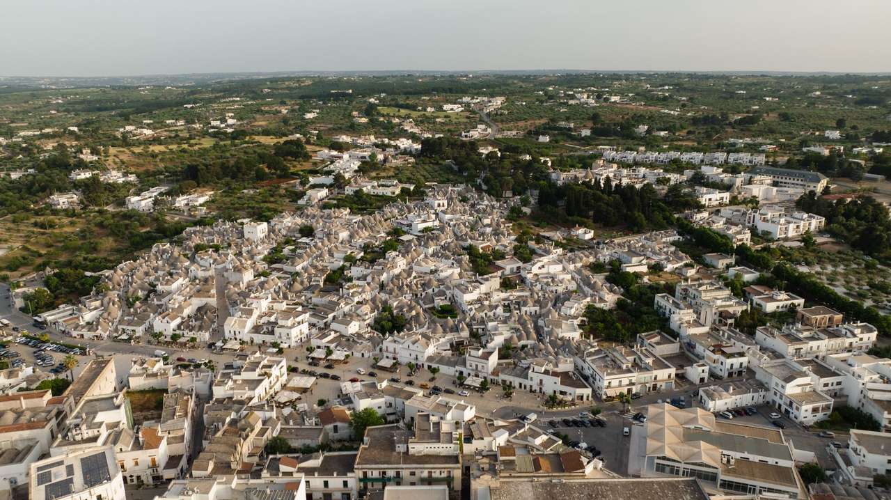 Aerial view of Alberobello with iconic trulli houses and surrounding green landscape, Puglia, Italy