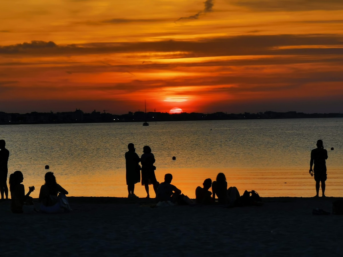 Silhouettes of people on Rimini beach at sunset, Adriatic coast, Emilia-Romagna, Italy