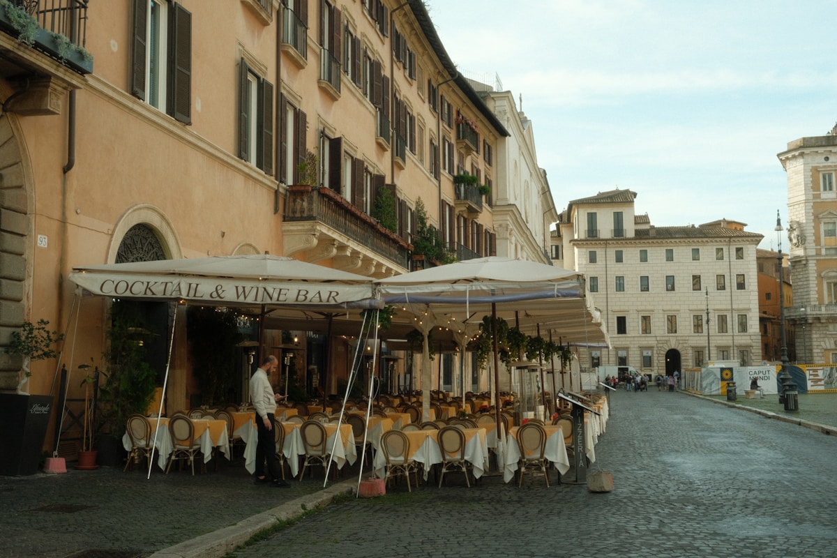 Outdoor restaurant with tables set on a cobblestone square, Rome, Italy