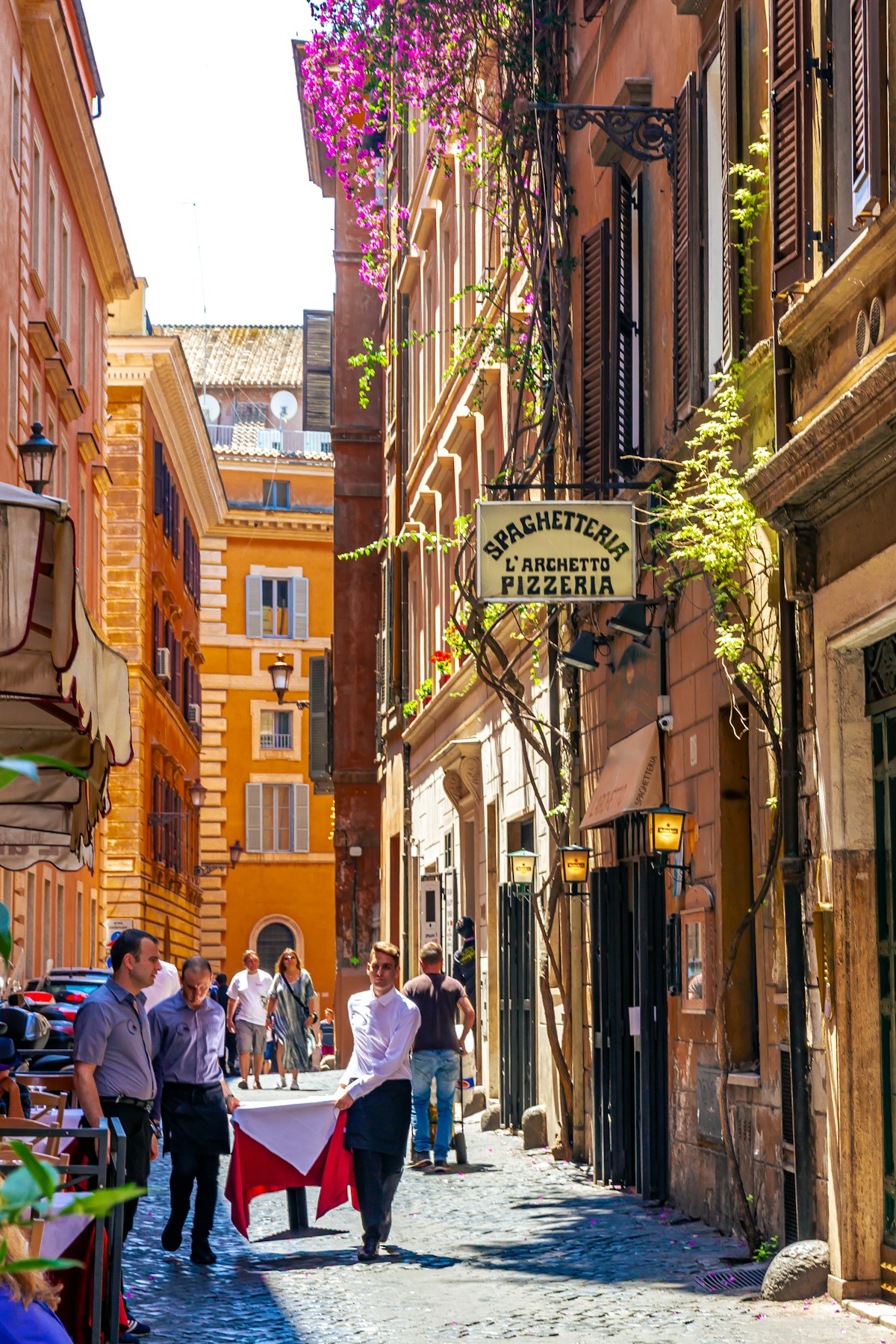 Narrow street with people walking, Rome, Italy