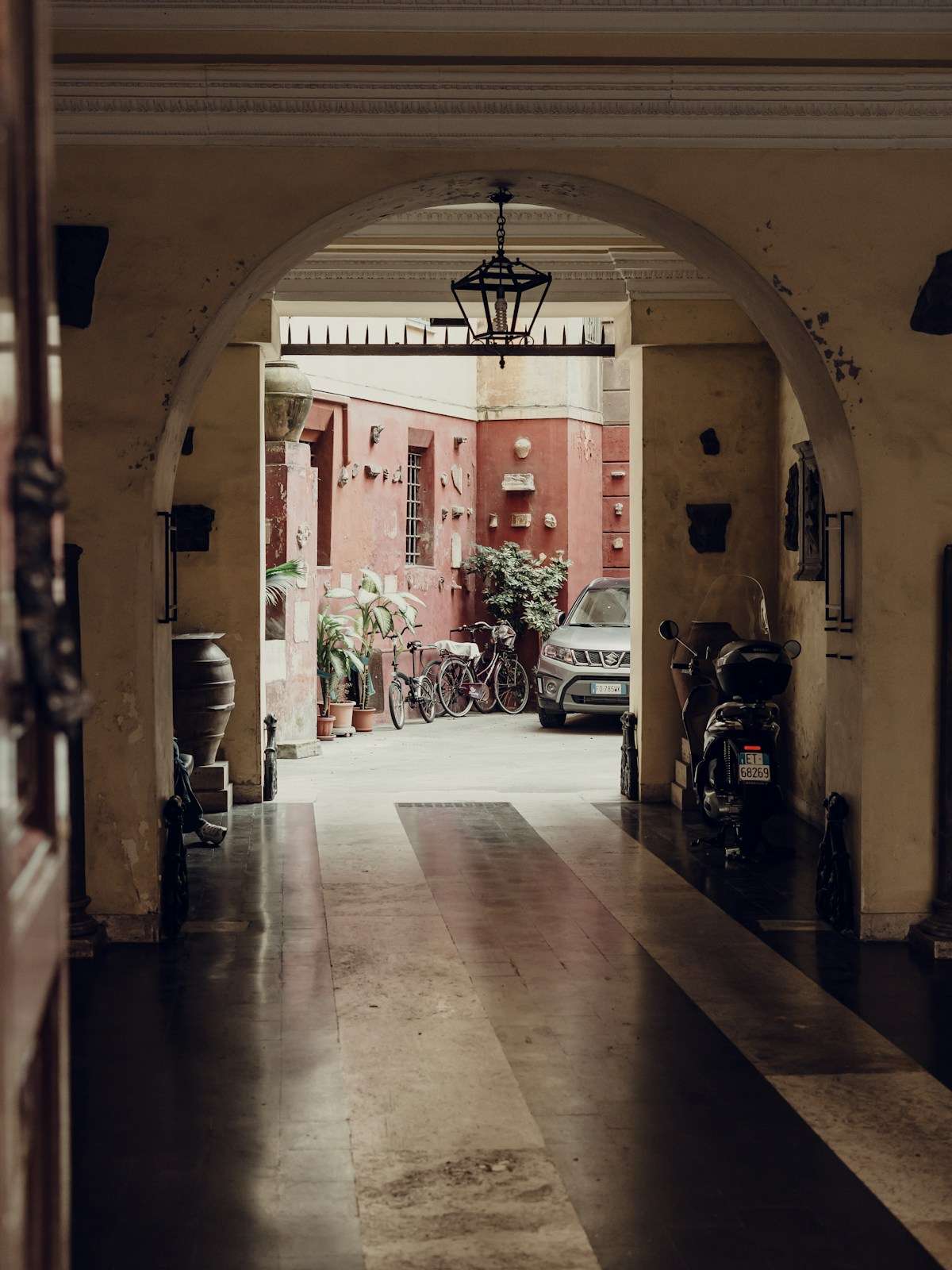 Arched entrance to a historic courtyard in Rome, Italy