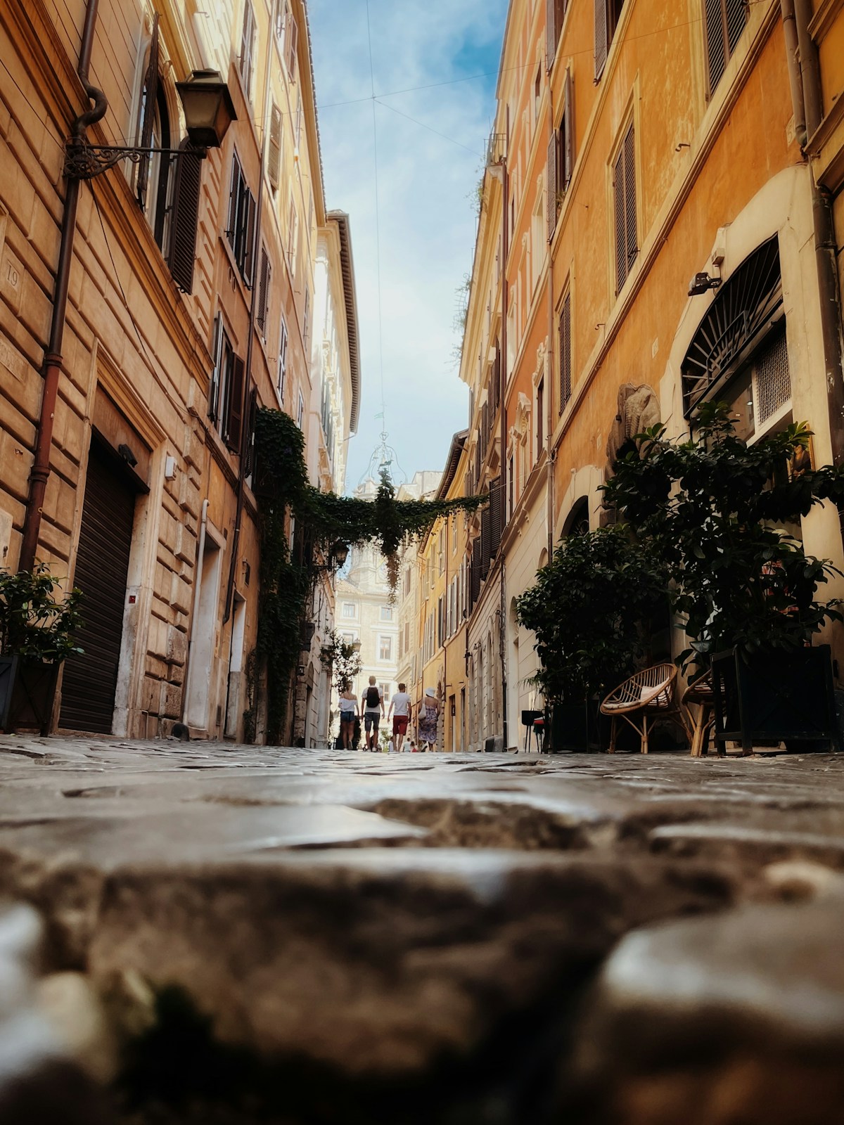 Narrow street in Rome with people walking, Italy