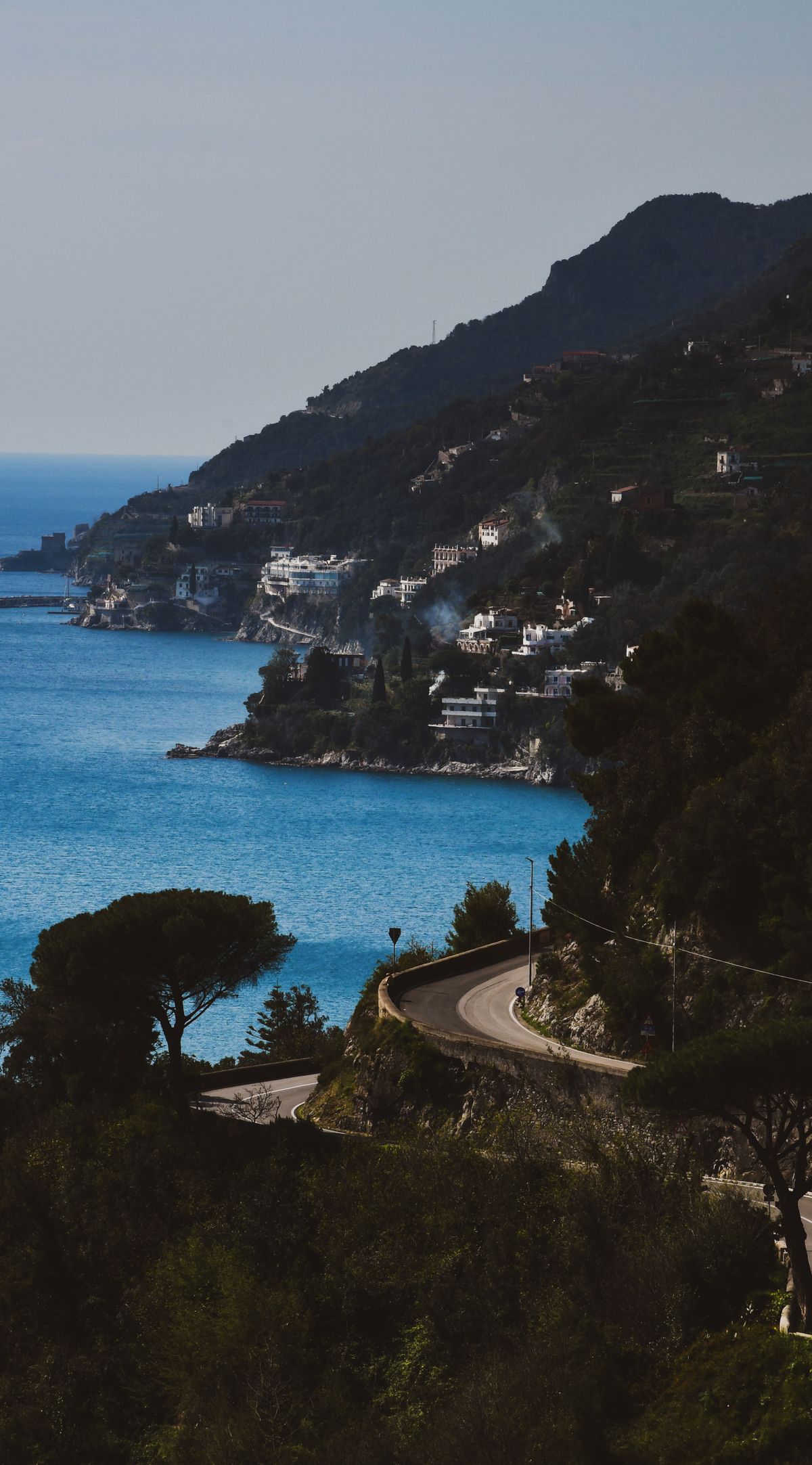 Winding coastal road hugging the cliffside above turquoise sea, Amalfi Coast, Campania, Italy