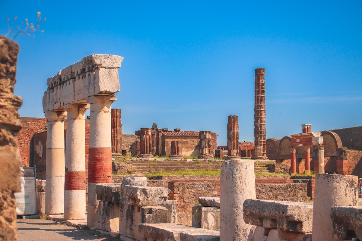Ruins of the ancient city of Pompeii with Roman columns under blue sky, Italy