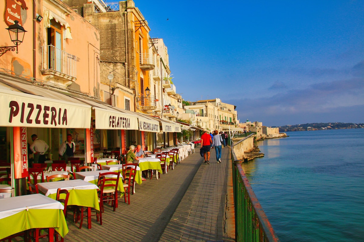 Waterfront restaurants with outdoor seating on a promenade, Sicily, Italy