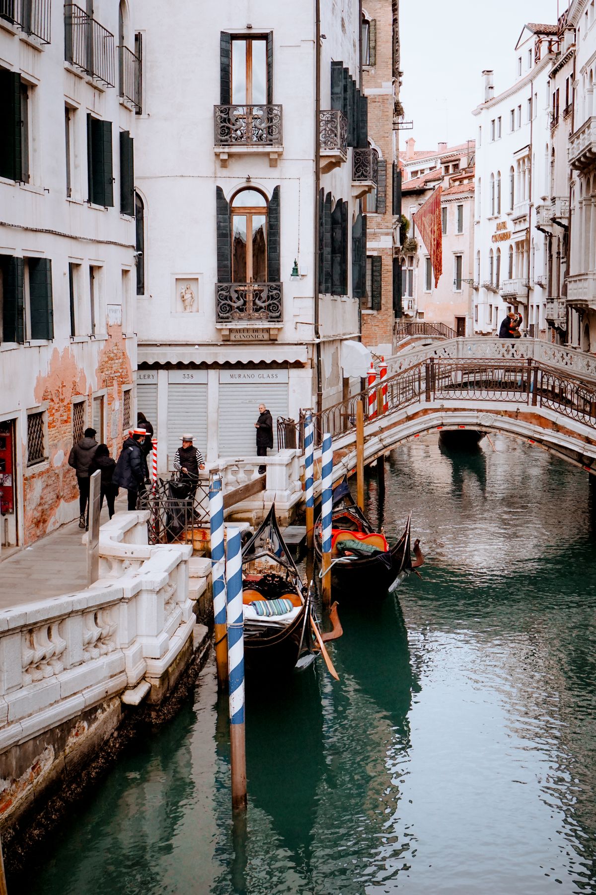 Gondolas moored on a narrow Venice canal beside historic stone buildings, Italy